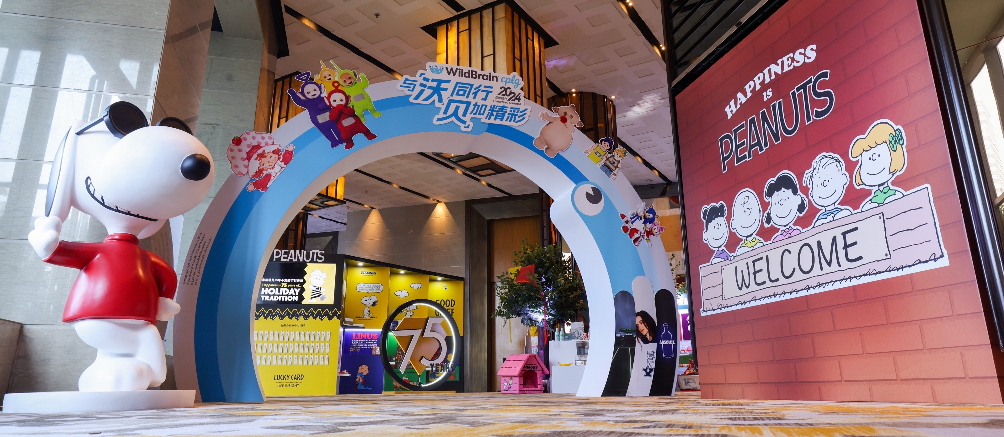 活动展示,包括带有 WildBrain 品牌的圆形入口,以及史努比小猎犬雕像。